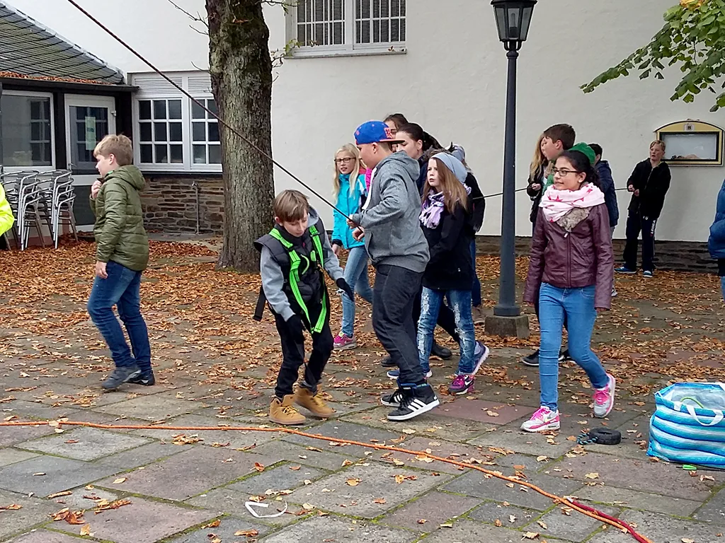 Jugendliche spielen auf dem Hof ein Bewegungsspiel.